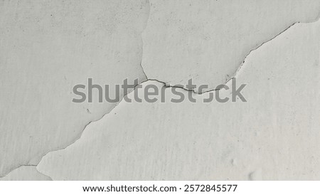 Close-up of a cracked white wall surface background showing damage and texture, symbolizing deterioration, aging, or structural issues in buildings or construction materials.