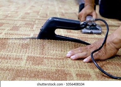close-up of a craftman connecting the wall to wall carpet with heat bond iron.