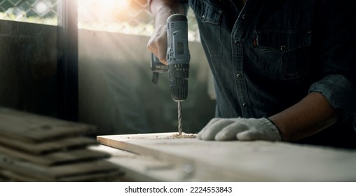 Closeup Craftman Hands Using Electronic Drill At Shop.