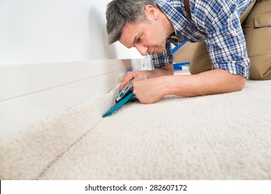 Close-up Of A Craftsman Fitting Carpet On Floor
