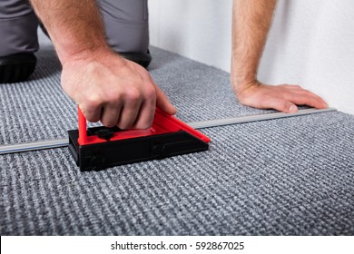 Close-up Of Craftsman's Hands Laying Carpet On The Floor
