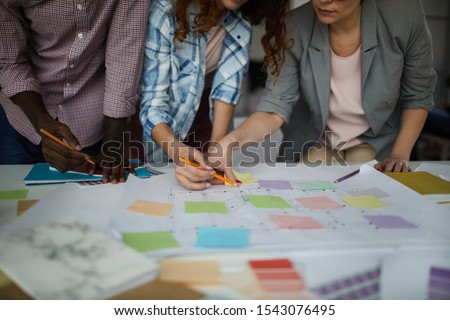 Closeup of creative business team working on design project focus on table with roadmap and colorful stickie notes, copy space
