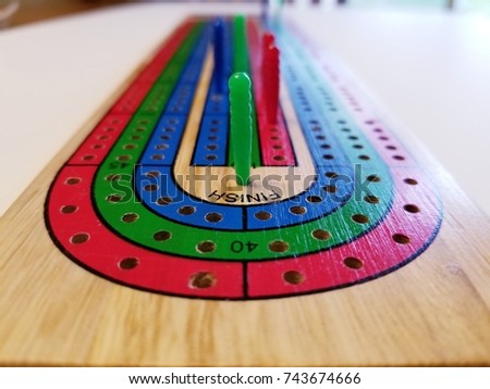 Closeup of Cribbage Board Winning Peg on White Background