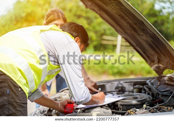Closeup and crop auto repair checking engine\
and post a list of repairs according to customer orders with sun\
and lens flare\
background.