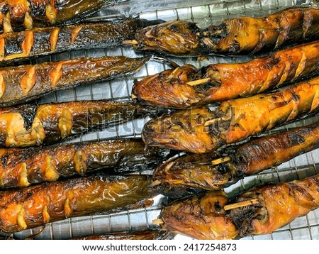 Closeup and crop grilled catfish on stove. Delicious thai food in market.