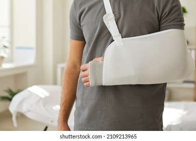 Closeup crop of injured man wear sling on broken leg. Unwell guy with protective bandage gear on arm, have injury or trauma. Rehabilitation concept. Healthcare and medicine. Health insurance cover.