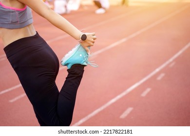 Closeup And Crop Legs Of Young Female Warm Up Outdoor Morning Before Workout And Jogging At The Football Stadium With Sunbeam.