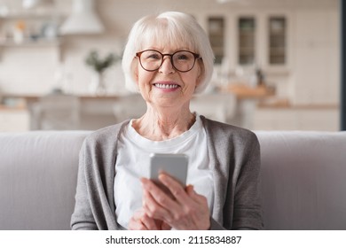 Closeup cropped front view photo of senior old elderly caucasian woman grandmother using smart phone cellphone for e-banking e-commerce, surfing social media online at home - Powered by Shutterstock