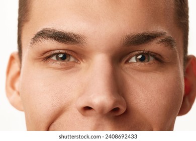 Close-up cropped image of male face, eyes, nose and eyebrows against white studio background. Concept of male beauty, skin care, spa, cosmetology, men's health