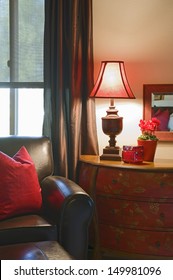 Closeup Of Cropped Leather Sofa With Lit Lamp At Home