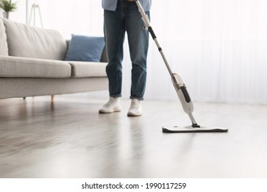 Closeup cropped low section of woman washing hardwood laminate flooring using water spray mop pad and refillable bottle with cleaning agent. Chores Concept. Blurred Background, Free Copy Space - Powered by Shutterstock