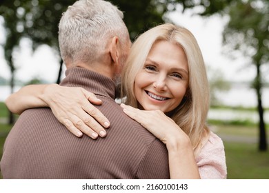 Closeup Cropped Photo Of Trust And Love Concept. Caucasian Mature Heterosexual Couple Hugging Embracing Together While Walking On Romantic Date In Park Forest Outdoors.