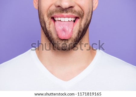 Close-up cropped portrait of attractive, trendy, stylish, toothy man with healthy teeth, showing tongue out, over pastel violet purple background