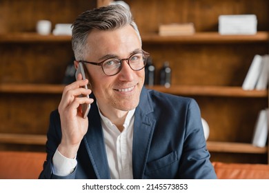 Closeup cropped portrait of smiling wealthy caucasian mature middle-aged businessman employee lawyer boss ceo freelancer talking on cellphone, calling colleagues with good connection in office