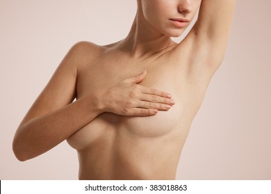 Closeup cropped portrait young woman with breast pain touching chest colored isolated on background - Shutterstock ID 383018863
