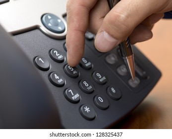 Close-up Cropped Shot Of Human Hand Dialing From A Modern Land Line Phone.