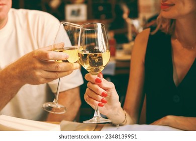 closeup with cropped shot of lovers holding hands over romantic valentine’s day dinner table.Couple clinking glasses at Christmas day in restaurant.Happy young couple enjoying nice romantic dinner. - Powered by Shutterstock