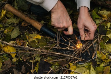 Close-up cropped shot of scout male lighting fire, starting campfire with fire starting tools and knife. Traveler tourist striking ferrocerium rod to make bonfire on hiking adventure. - Powered by Shutterstock