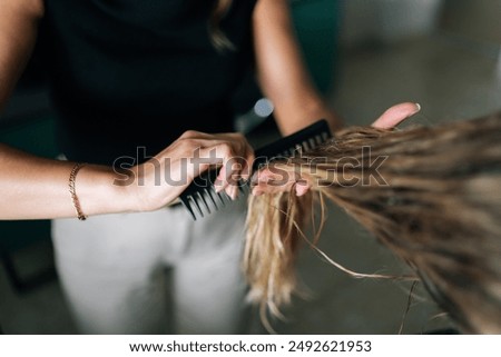 Similar – Foto Bild Abgeschnittene, nicht erkennbare Friseurin bei der Verwendung eines elektrischen Trimmers an den Haaren eines männlichen Kunden im Salon