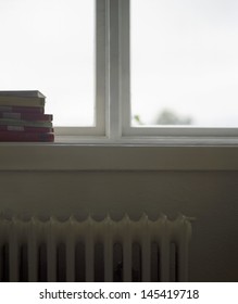 Closeup of cropped stack of books on windowsill