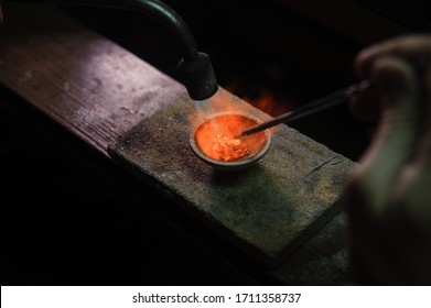 Close-up of a crucible with molten metal being heated, showcasing the process of jewelry crafting and metalwork. - Powered by Shutterstock