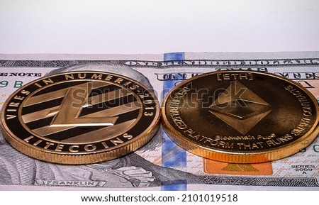 A closeup of Crypto coins LTC and ETH on 100 US dollar on isolated white background