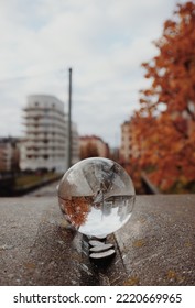 Close-up Of Crystal Ball On Stone Wall Against Buildings In City