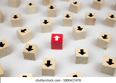 Close-up cube wooden toy blog with arrow head icons pointing to opposite directions for business change leader to growth and success concepts.