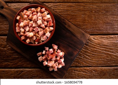 Closeup Of Cubes Of Bacon On A Rustic Wooden Board. Raw.