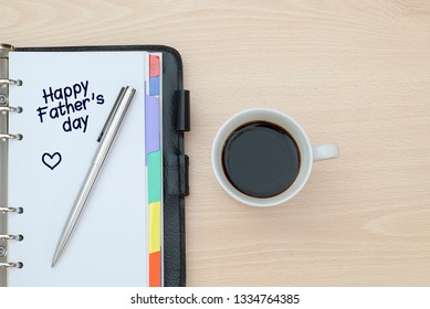 Close-up of a cup of coffee and notebook  writen  Happy Father's Day - Powered by Shutterstock