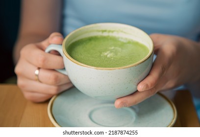 Close-up, A Cup With Green Matcha Drink In Female Hands.