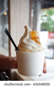 Closeup Of A Cup With Organic Soft Serve Ice Cream And Topped With Honeycomb Served In A Plastic Takeaway, Healthy Eating Concept.