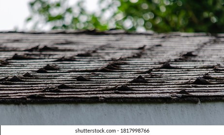 Close-up Of Curled Roofing Shingles On A Residential Rooftop