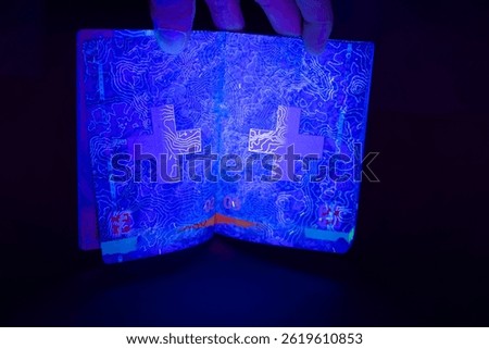 Close-up of current version of Swiss biometric passport with relief of Gotthard mountain pass illuminated by UV light. Photo taken April 28th, 2025, Zurich, Switzerland.