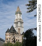 Closeup of the Custom Clock Tower in Boston Masssachusetts with blue skies and white clouds in background
