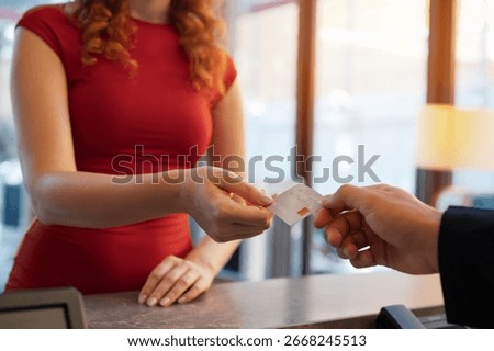 Close-up customer hand while paying for services at hotel. Female guest using a credit card for payment. service hotel and payment concept