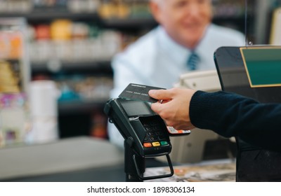 Close-up of a customer pays for shopping at a supermarket checkout. Customer paying with a credit card in a store. - Powered by Shutterstock