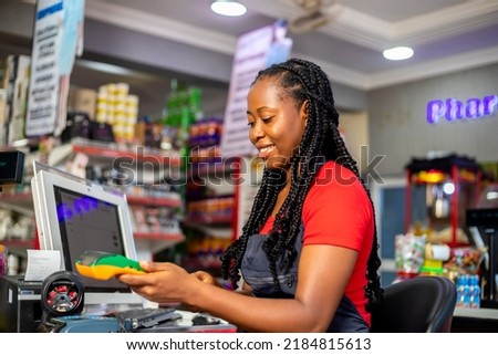 Closeup of a customer using her credit card to pay for goods brought from supermarket