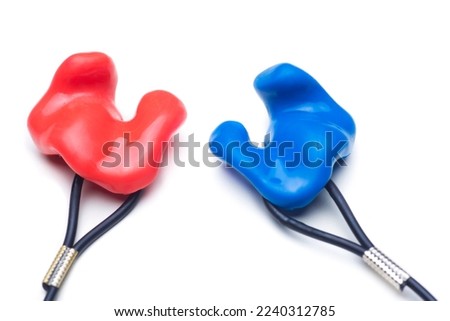 Close-up of customized earplugs of silicone for hearing protection or swimming in red and blue isolated on white background