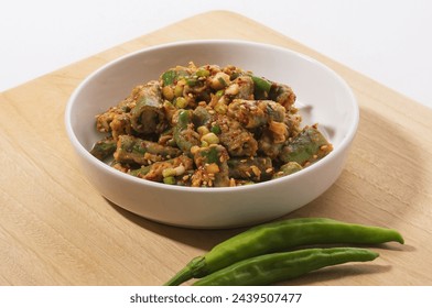 Close-up of cut seasoned shishito peppers with seasoning and sesame seeds on bowl with raw green pepper on wood cutting board, South Korea
 - Powered by Shutterstock