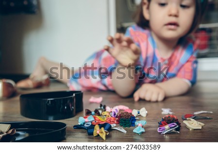 Similar – Baby Mädchen spielt mit Haarspangen, die auf dem Boden liegen.