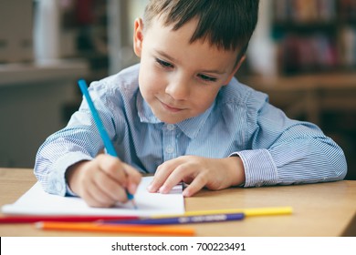 Close-up, Cute  Boy Doing Homework,  Coloring Pages, Writing And Painting. Children Paint. Kids Draw. Preschooler With Books At Home. Preschoolers Learn To Write And Read. Creative Boy.