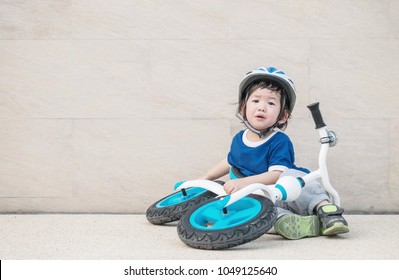 Closeup Cute Kid Sit At Marble Floor And Cry Because Of Falling Bike At The Car Park Textured Background With Copy Space