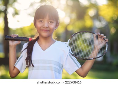 Closeup cute little asian girl holding a badminton racket, Outdoor