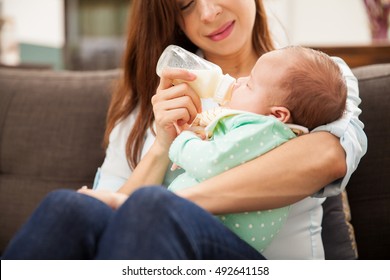 Closeup Of A Cute Newborn Baby Drinking Formula From A Bottle Held By Her Mom