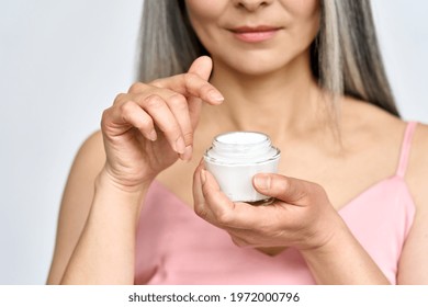 Closeup Cutout Portrait Of Mid Age Woman With Hands Holding Face Cream For Older Skin. Advertising Of Anti Wrinkle Antiaging Whitening Rejuvenation Uv Protection Treatment For Women After Menopause.