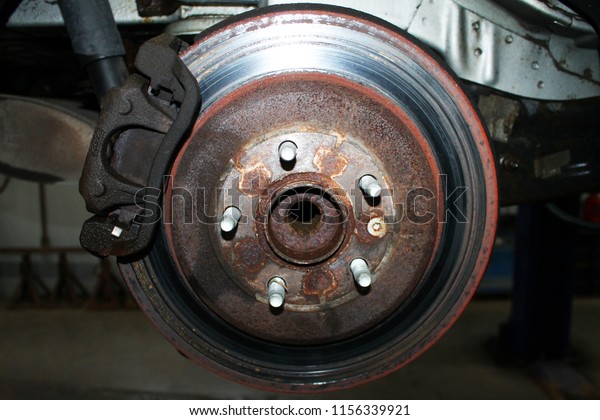 Close-up of damaged brake rotors. Rotors are\
rusted, scored, and\
grooved.
