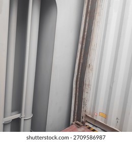 Close-up of a damaged container cell guide inside a ship's cargo hold, showing structural damage and heavy wear on the steel frame