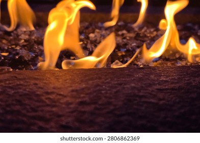 Close-Up of Dancing Flames Over Fire Glass in Outdoor Gas Fire Pit