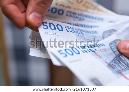 close-up of Danish kroner banknotes held in hands. Concept showing the economy in Denmark.